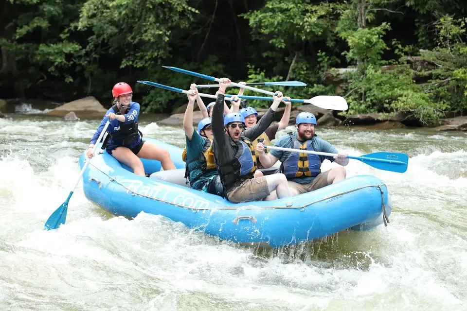 A rafting group celebrating with paddles raised on the Ocoee